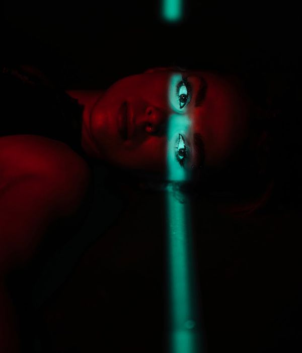 Woman doing light cardio exercises in a futuristic dark room with cyan lights.